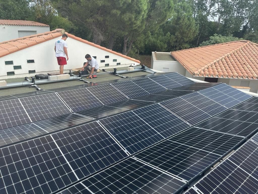 Technicien posant des modules photovoltaïques sur une toiture en tuiles